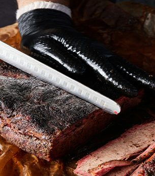 Sliced smoked brisket with rich bark and juicy interior from AHEAD Catering in Shreveport, Louisiana.